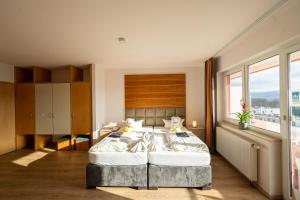 ein Schlafzimmer mit einem großen Bett und einem großen Fenster in der Unterkunft Savoy Hotel Bad Mergentheim in Bad Mergentheim