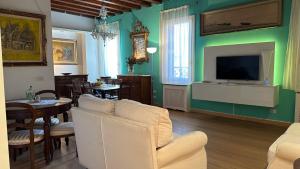 a living room with a tv and a dining room at Albrizzi Charme apartment in Venice