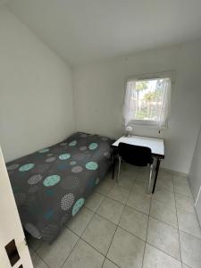 een slaapkamer met een bed, een bureau en een raam bij Pavillon à 400m de la plage avec piscine in Valras-Plage