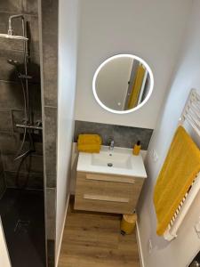 y baño con lavabo y espejo. en PROMO Maison de centre ville - Proche Puy du Fou, en Cholet