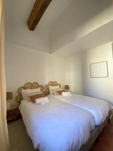 um quarto com uma cama grande e lençóis brancos em Deux chambres avec terrasse dans le centre ville d'Aix en Provence em Aix-en-Provence