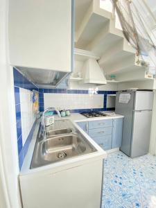 a small kitchen with a sink and a refrigerator at Arime Apartment in Ischia
