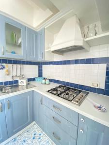 - une cuisine bleue et blanche avec cuisinière dans l'établissement Arime Apartment, à Ischia