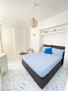 a bedroom with a large bed with blue pillows at Arime Apartment in Ischia