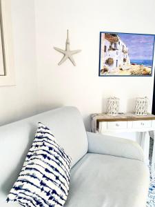 Arime Apartment في ايسكيا: غرفة معيشة مع أريكة بيضاء و نجمة على الحائط