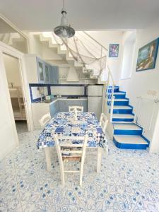 Arime Apartment في ايسكيا: غرفة طعام مع طاولة والبلاط الأزرق والأبيض