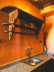 a kitchen with a sink and a wooden wall at Panorama Guesthouse in Agadir