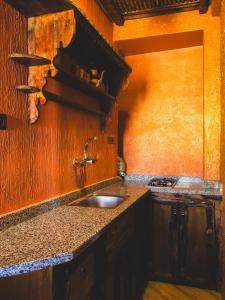 een keuken met een wastafel en een houten muur bij Panorama Guesthouse in Agadir