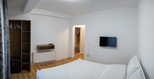 um quarto branco com uma cama e uma televisão na parede em Hotel Lux em Struga