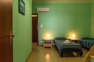 2 camas en una habitación con paredes verdes en Appartamento B - Le Terrazze, en Ribera