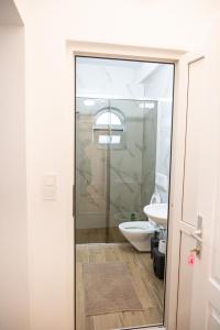 a bathroom with a toilet and a glass shower door at Hotel Lux in Struga