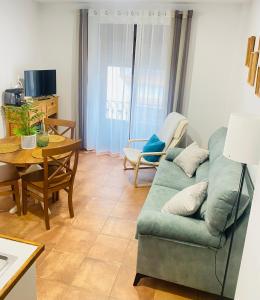 a living room with a green couch and a table at Apartamentos rurales, La Casa de Baltasar in Fondón
