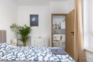Schlafzimmer mit einem Bett mit einer blauen und weißen Bettdecke in der Unterkunft Warsaw-Aparts Stegny in Warschau