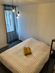 dos zapatillas amarillas sentadas encima de una cama en PROMO Maison de centre ville - Proche Puy du Fou, en Cholet