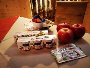 deux pommes et deux caisses de nourriture sur une table dans l'établissement B&B Ronco Carbon, à Gallio
