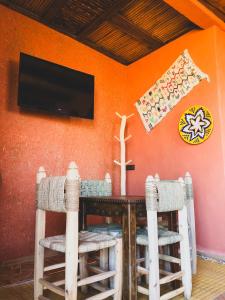 een eetkamer met een tafel en stoelen en een tv bij Panorama Guesthouse in Agadir