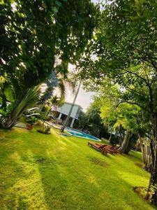 un parco con piscina, tavoli da picnic e alberi di VILLA MADERA DEL SOL --- Playa Las Ballenas a Las Terrenas