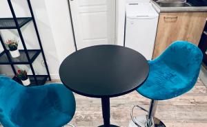 a table and two blue chairs in a kitchen at Appartement cosy deux pièces proche centre ville de Marseille in Marseille