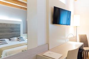 Schlafzimmer mit einem Bett, einem Schreibtisch und einem Spiegel in der Unterkunft Hotel Alexander in Mestre