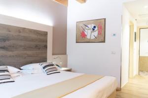 una camera con letto bianco e testiera in legno di Hotel Alexander a Mestre