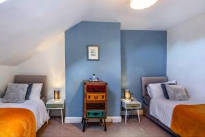 two beds in a room with blue walls at The Harrogate House - 4 Bed Townhouse in Harrogate