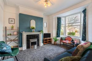 a living room with a couch and a fireplace at The Harrogate House - 4 Bed Townhouse in Harrogate