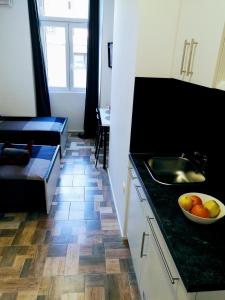 a kitchen with a sink and a bowl of fruit on a counter at Pula Center - Studio Apartments in Pula