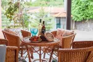 a table with a bowl of fruit and bottles of wine at Quinta do Santo by LovelyStay in Santo da Serra