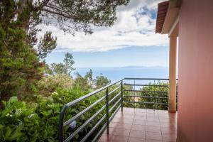 una casa con balcón y vistas al océano. en Quinta do Santo by LovelyStay, en Santo da Serra