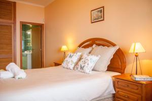 1 dormitorio con 1 cama grande con sábanas y almohadas blancas en Quinta do Santo by LovelyStay, en Santo da Serra