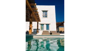 a villa with a swimming pool in front of a house at Cloud Blue in Mikonos
