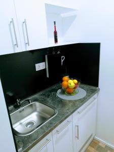 a kitchen counter with a sink and a bowl of fruit at Pula Center - Studio Apartments in Pula