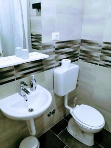 a bathroom with a white toilet and a sink at Pula Center - Studio Apartments in Pula