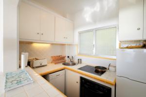 Una cocina con gabinetes blancos y un fregadero. en 1Mirand3, en Llafranc 9 fotos más