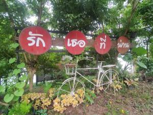 a sign with a bike in front of some signs at Doi Sang Farm Stay - ดอยซางฟาร์มสเตย์ in Ban Huai Kom