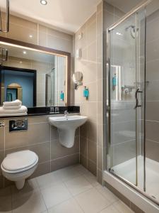 La salle de bains est pourvue d'un lavabo et d'une douche. dans l'établissement Academy Plaza Hotel, à Dublin