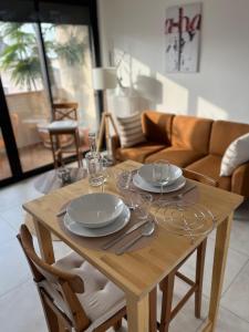 a wooden table with plates and utensils on it at L’appartement du bonheur in Issoire