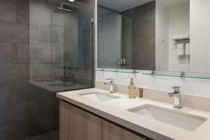 a bathroom with two sinks and a large mirror at Residencias Cityzen cerca del Aeropuerto in Echeverría