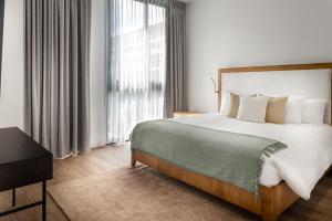 a bedroom with a large bed and a large window at Residencias Cityzen cerca del Aeropuerto in Echeverría