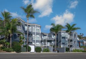 a building with palm trees in front of a street at Beachfront Inn and Suites at Dana Point in Capistrano Beach