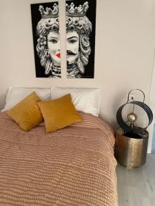 a bedroom with a bed with two pictures on the wall at Attico “the Queen” in Caravaggio
