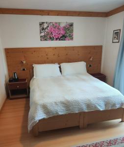 una camera con un grande letto con testiera in legno di B&B Alverà a Cortina dʼAmpezzo