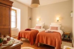 a bedroom with two beds with orange sheets at Les Balcons sur la Loire in Chalonnes-sur-Loire