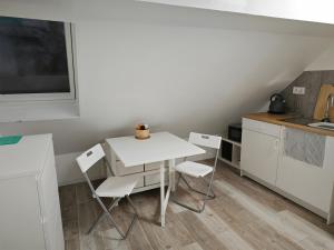 un piccolo tavolo bianco con sedie in cucina di Grünes Idyll im Herzen Kölns a Colonia