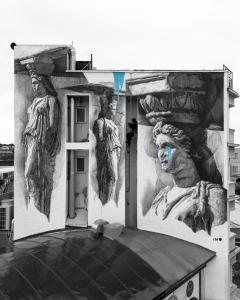 a mural on the side of a building with statues at The Athens Version Luxury Suites in Athens