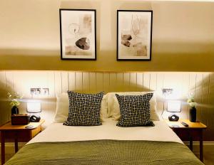 a bedroom with a bed with three pictures on the wall at The Punchbowl Lapworth in Solihull