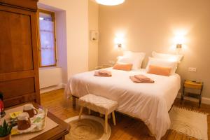 1 dormitorio con 1 cama blanca grande y 2 toallas en Les Balcons sur la Loire, en Chalonnes-sur-Loire