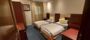 - une chambre avec 2 lits dans une chambre d'hôtel dans l'établissement نجمة العنان للشقق المخدومة, à Tabuk