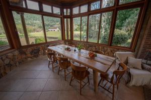 Una habitación grande con una mesa y sillas de madera. en Monã, en Canela