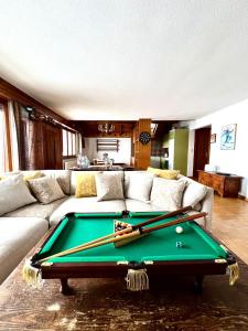 a living room with a pool table with bats on it at tHE Eagle Nest Duplex - Your Mountain Retreat in Chalais